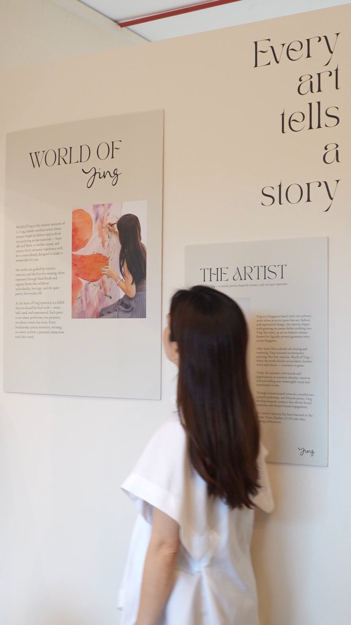 Ying at her exhibition wall